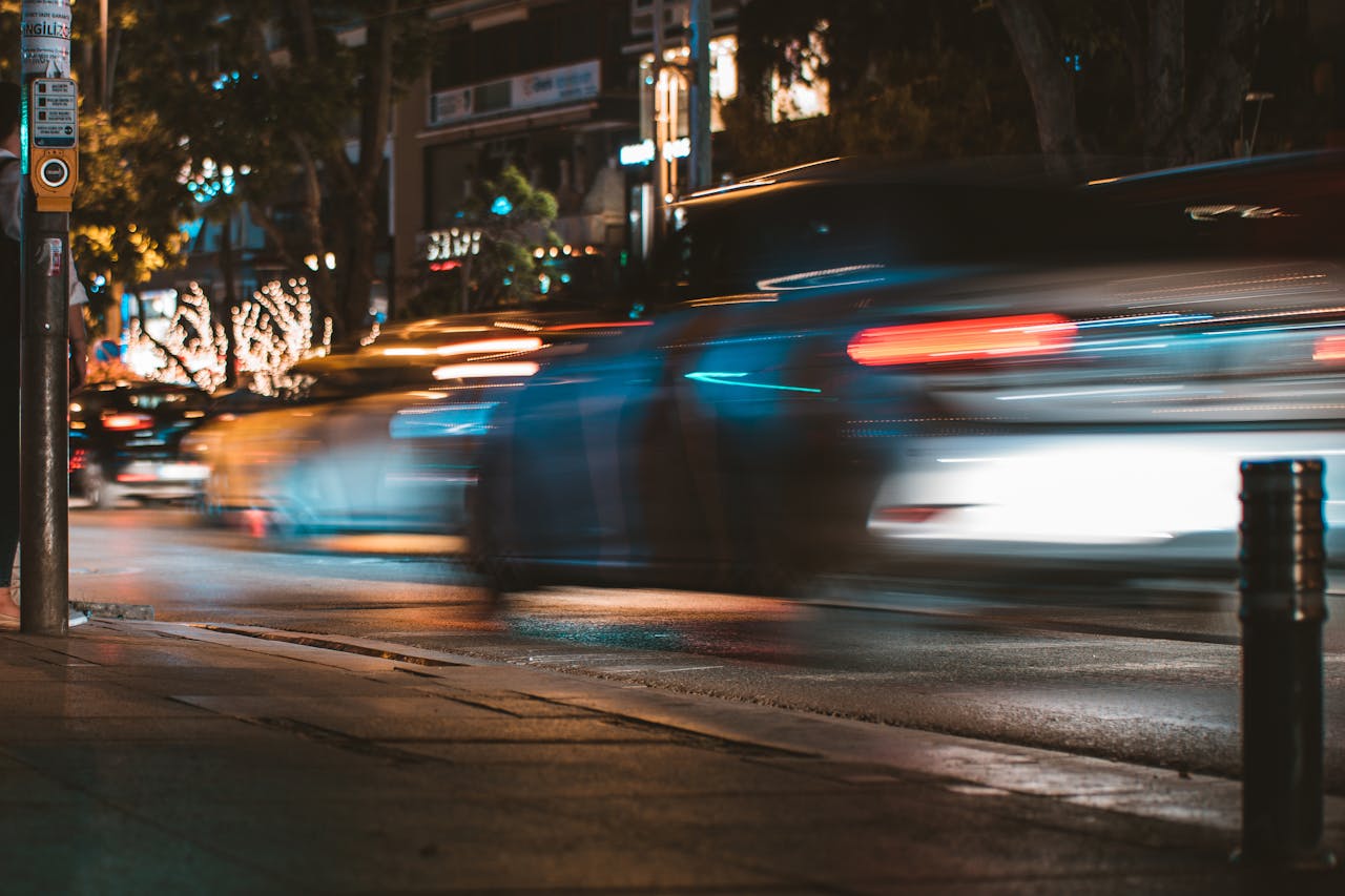 Long exposure capture of urban traffic showcasing light streaks and busy city life at night.
